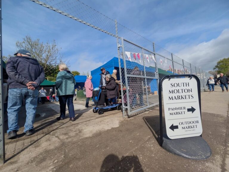 Visitors entering Drovers Yard beside the market direction sign